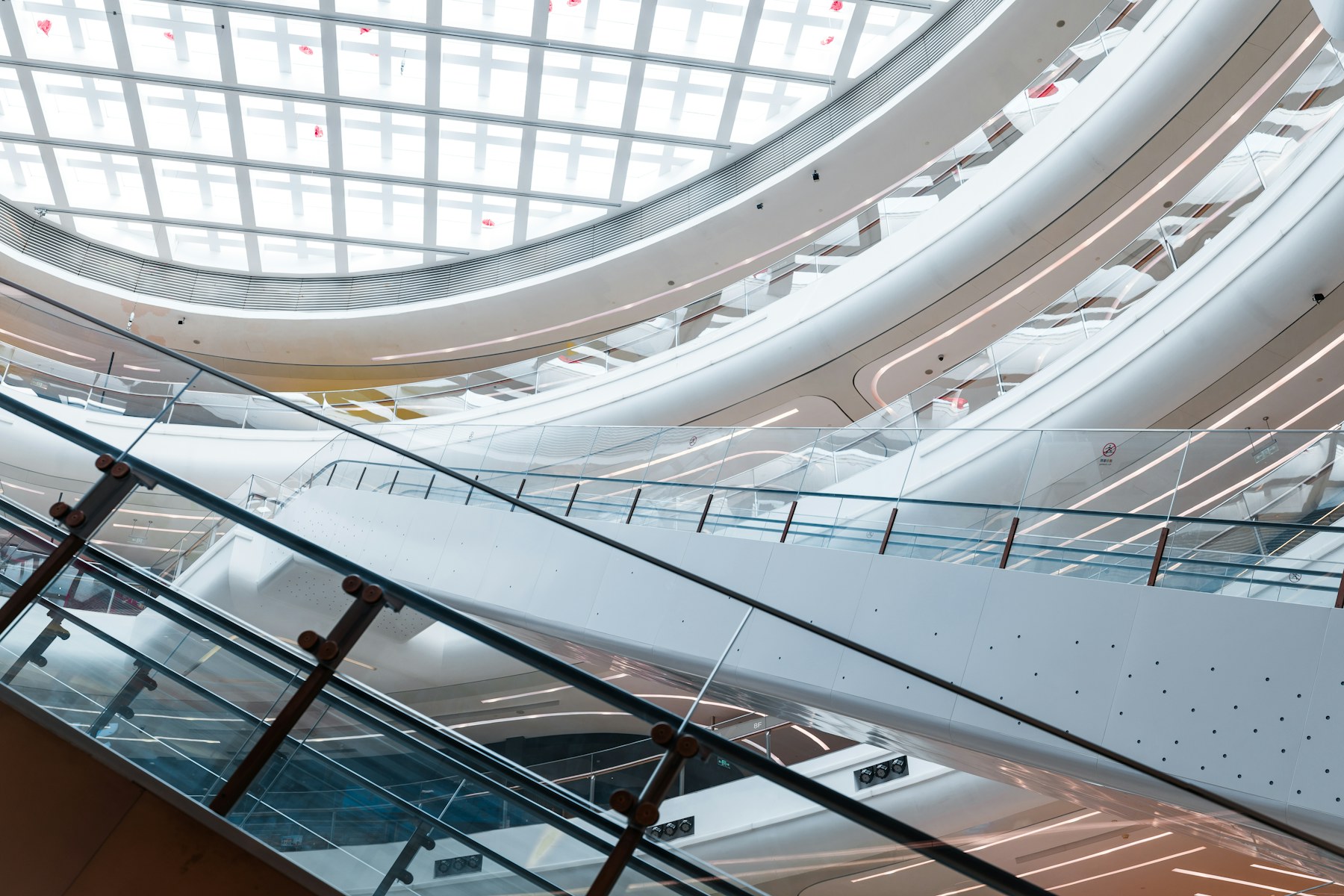 A real modern commercial atrium with escalators and glass railings