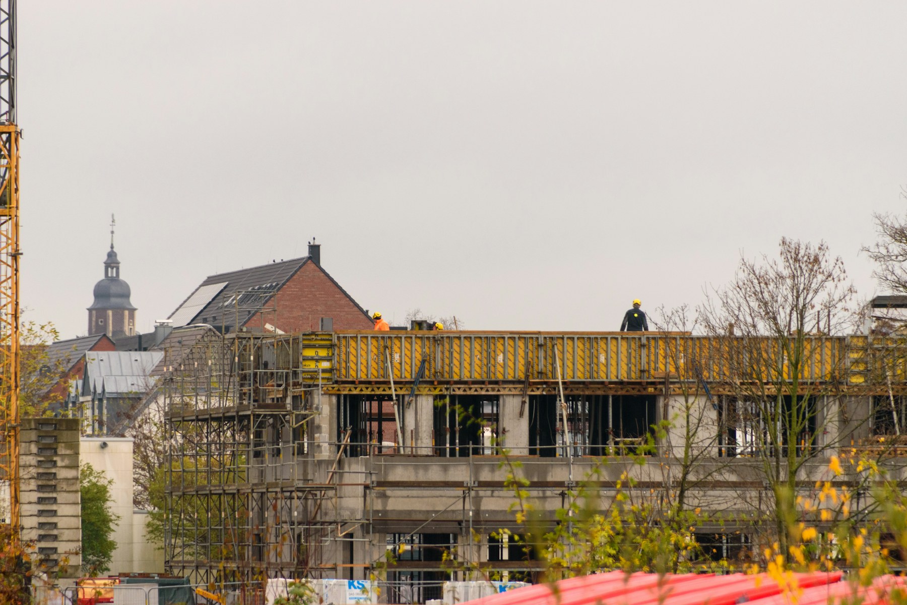 A real construction site with workers, scaffolding and active structure work